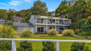 a white house with a white fence at 'Footsteps to the Bay' by HolidayCo in Pretty Beach