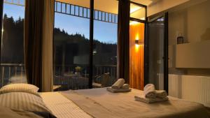 1 dormitorio con 1 cama con toallas. en Didveli Gallery Bakuriani B202 დიდველი გალერეა ბაკურიანი B202, en Bakuriani