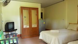 a small room with a bed and a television at Happy Resort in Khanom