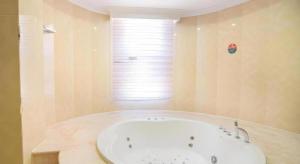 eine weiße Badewanne in einem Badezimmer mit Fenster in der Unterkunft GreenTree Inn Jiangsu Wuxi Xishan DongTing Erquan East Road XinGuang Newly Estate Express Hotel in Wuxi + 128 Fotos