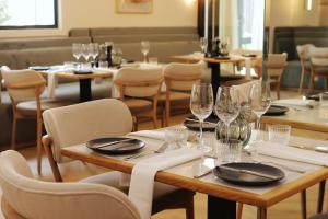 a restaurant with tables and chairs and wine glasses at The Max Hotel Sandton in Johannesburg