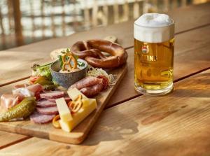een houten tafel met een bord eten en een glas bier bij Die Waldstube in Bromskirchen +28 foto's