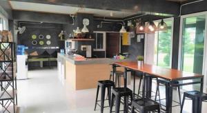 a kitchen with a wooden table and some stools at Loft Village in Ban Khlong Kathon
