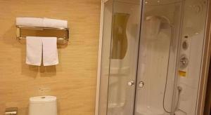 La salle de bains est pourvue d'une douche, de toilettes et de serviettes. dans l'établissement GreenTree Inn Zibo Renmin Park, à Zibo 24 autres photos