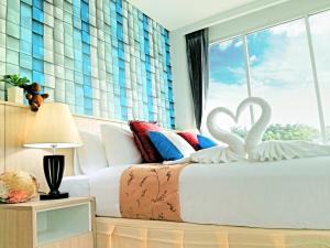 a bedroom with a bed with two swans on it at The Wings Boutique Hotels Krabi Koh Lanta in Ko Lanta