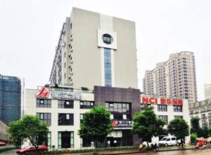 un bâtiment avec une horloge sur le côté dans l'établissement Jinjiang Inn Jinhua Binhong Road, à Jinhua