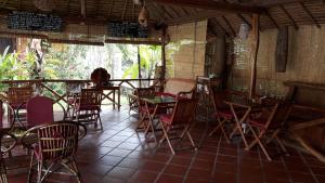 a restaurant with tables and chairs in a room at Bird of Paradise Bungalows in Kep