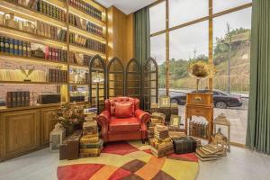 eine Bibliothek mit einem roten Stuhl und vielen Büchern in der Unterkunft James Joyce Coffetel·Suqian Bus Station in Suqian