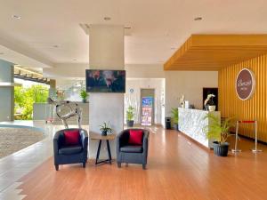 um saguão com duas cadeiras e uma mesa em Burza Hotel Lubuk Linggau em Lubuklinggau