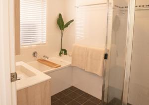 a bathroom with a tub and a sink and a shower at Coastal Courtyard Retreat Jasmine Hideaway Sunshine Coast in Kawana Waters +20 photos