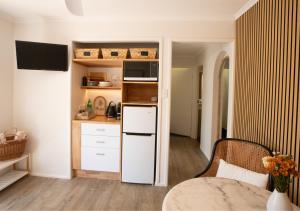 una piccola cucina con frigorifero bianco e forno a microonde di Coastal Courtyard Retreat Jasmine Hideaway Sunshine Coast a Kawana Waters