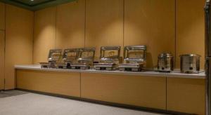 a counter with a row ofurgers and pots and pans at GreenTree Inn Anhui Bozhou West Guangming Road Tangwang Avenue Shall Hotel in Bozhou