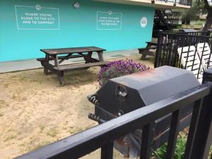 a grill sitting on a fence next to a picnic table at Park Pointe Hotel in South San Francisco