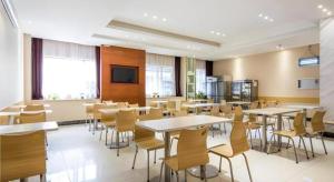 une salle à manger avec tables et chaises dans un bâtiment dans l'établissement City Comfort Inn Dongguan Humen Wanda High-speed Railway Station Beizha, à Dongguan