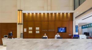 2 personnes assises dans un hall avec leurs ordinateurs portables dans l'établissement City Comfort Inn Dongguan Humen Wanda High-speed Railway Station Beizha, à Dongguan