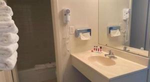 ein Badezimmer mit Waschbecken, Spiegel und Dusche in der Unterkunft Travelodge by Wyndham Powell in Powell