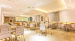 une grande chambre avec des tables et des chaises dans un bâtiment dans l'établissement City Comfort Inn Zhaoqing Qixingyan Scenic Area Xinghu Archway, à Zhaoqing