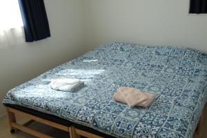 a bed with two pillows on top of it at 海に近い田舎にある新築家の丹霞阁 in Itoman