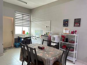 a kitchen with a table with chairs and a table and a kitchen with a counter at HOMESTAY MURAH MELAKA Melayu Sahaja in Malacca