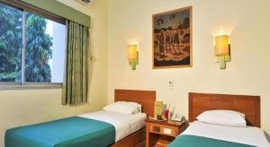 a bedroom with two beds and a window at Muria Hotel in Semarang +133 photos
