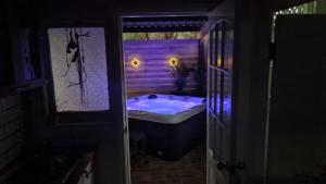 y baño con bañera con luces moradas. en R&R Roo & Rest, en Singleton 25 fotos más