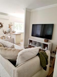 Una sala de estar con un sofá y un televisor de pantalla plana. en R&R Roo & Rest, en Singleton