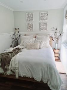 1 dormitorio blanco con 1 cama grande con sábanas y almohadas blancas en R&R Roo & Rest, en Singleton