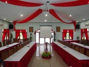a large room with red curtains and tables and chairs at The Luxio Hotel in Sorong