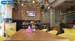 ein Esszimmer mit einem Holztisch und gelben Stühlen in der Unterkunft An Hotel Jakarta in Jakarta