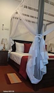 un dormitorio con una cama con mosquitera en Ocean's Whisper, en Tangalle