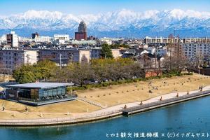a city with mountains in the background and a body of water at Comfort Hotel Toyama in Toyama