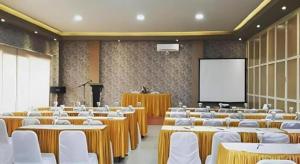 a conference room with tables and chairs and a screen at Sunrise Hotel in Malang +136 photos
