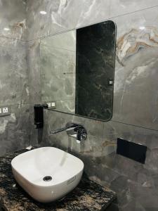 Un baño con un lavabo blanco y un espejo. en Hotel Florian, en Jaipur 4 fotos más