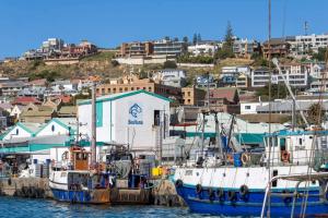 two boats docked at a marina with buildings in the background at Gemma in Mossel Bay +22 photos