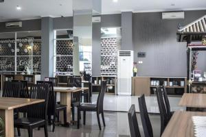 une salle à manger avec des tables et des chaises en bois dans l'établissement Asoka Luxury Hotel, à Tanjungkarang 119 autres photos