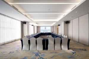 a conference room with chairs and a projection screen at Rezen Hotel Huaxia Xiamen in Xiamen