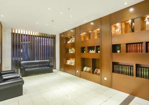 a waiting room with a leather chair and books at City Comfort Inn Wuhan Hankou Railway Station West Square in Wuhan