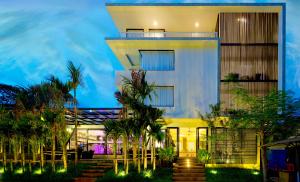 un bâtiment avec des palmiers en face de celui-ci dans l'établissement Apsara Residence Hotel, à Siem Reap