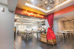 Un restaurante con mesas y sillas en una sala. en Grand Darmo Suite by AMITHYA, en Surabaya