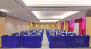- une salle de conférence avec des tables et des chaises bleues dans l'établissement City Comfort Inn Nanning Railway Station Guangxi University, à Nanning