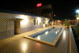 basen w nocy z budynkiem w obiekcie Puti Commercial Hotel w mieście Longtan