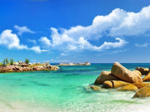 a beach with rocks in the ocean with a blue sky at Seaview Long Hai Hotel in Long Hai