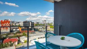 a balcony with a table and chairs and a view of a city at Annexe Apartments in Brisbane