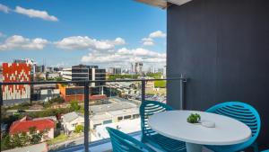 een balkon met een tafel en stoelen en uitzicht op de stad bij Annexe Apartments in Brisbane