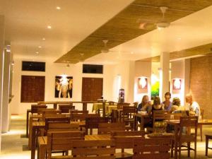 un groupe de personnes assises à des tables dans un restaurant dans l'établissement Neem Villas, à Tanjanagaram