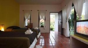 une chambre d'hôtel avec deux lits et une télévision à écran plat dans l'établissement Baan Chuengkao Resort, à Ranong