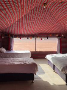 a room with three beds and a red ceiling at Golden Camp Tours in Wadi Rum +28 photos