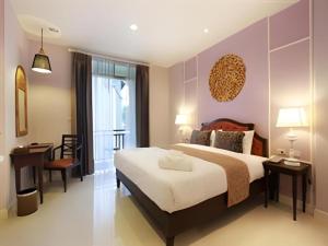 a bedroom with a bed and a desk and a chair at Khamthana the Colonial Hotel Chiangrai in Ban San Ton Ko (1) +72 photos