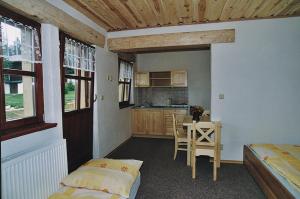 a room with two beds and a kitchen with a table at Pension Klose in Kubova Huť