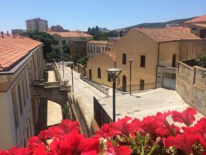 einen Blick auf eine Stadt mit roten Blumen im Vordergrund in der Unterkunft Sweet Home in Iglesias